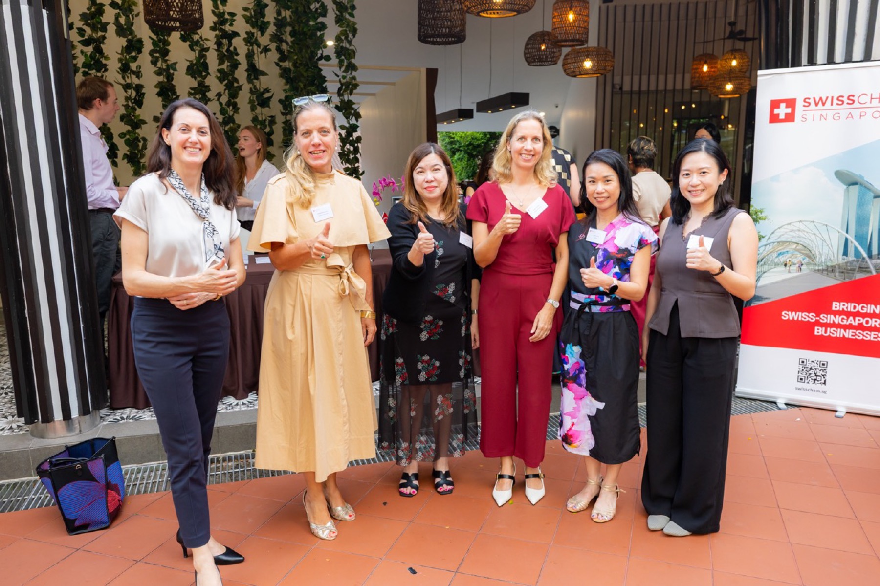 Guests standing beside a SwissCham Singapore banner
