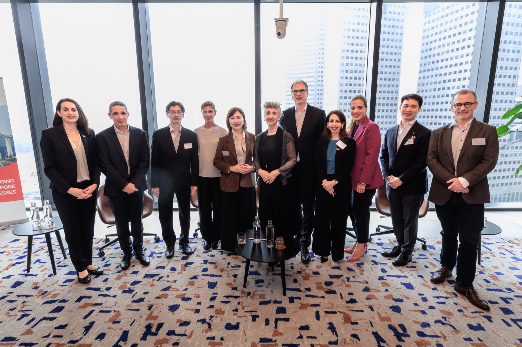 Speakers and hosts standing together by a window